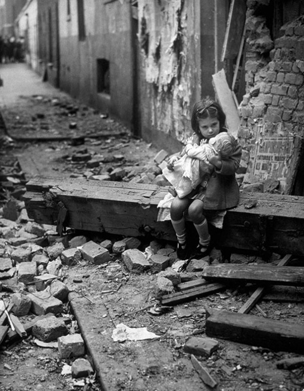 1940 : Un petite fille assise dans les ruines de sa maison à Londres