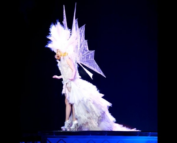 Gaga in a white leather bikini, angel wings, and a giant glittering headpiece