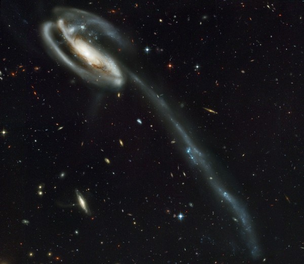 A wallpaper of distant galaxies is a stunning backdrop for a runaway galaxy